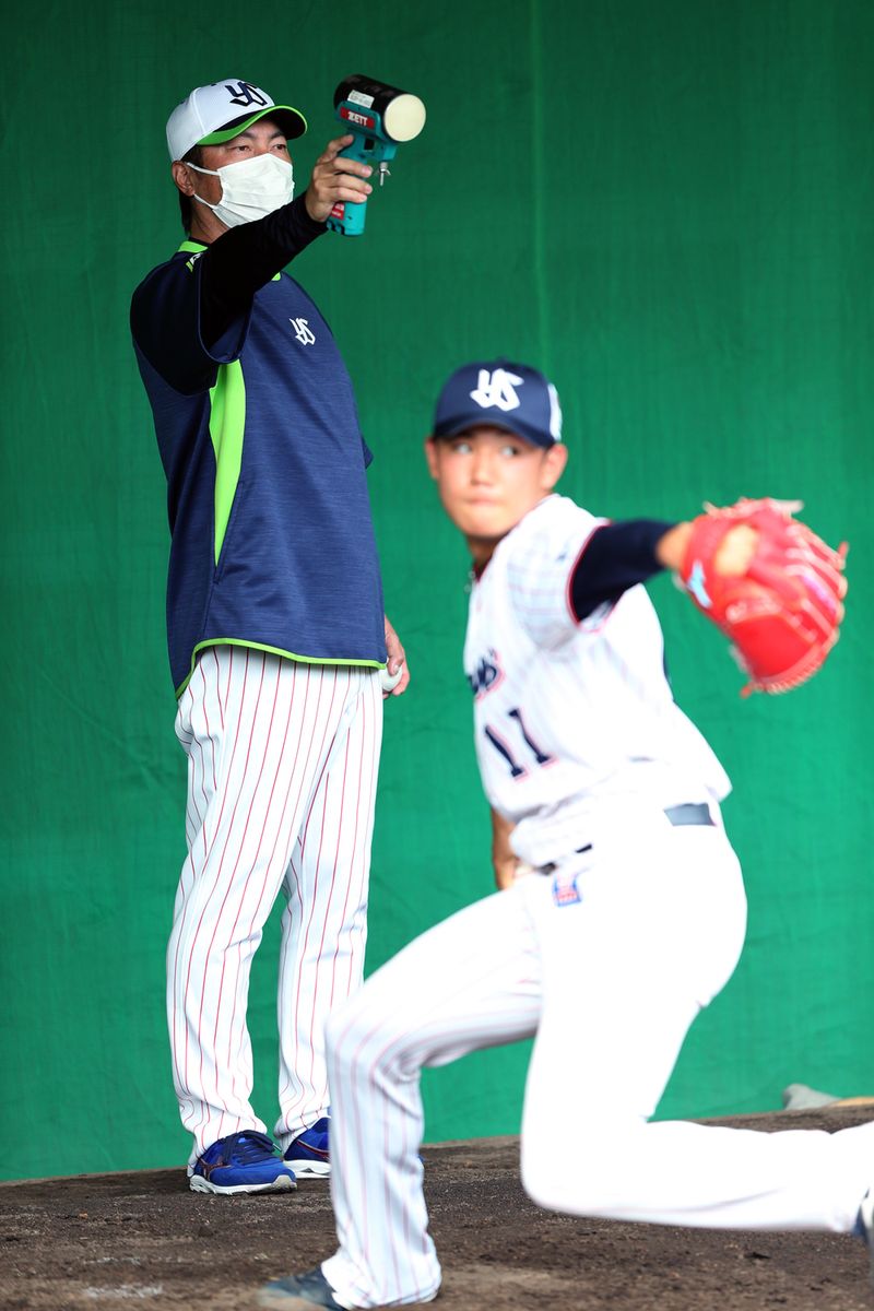 2021年2月10日=沖縄・浦添 　奥川恭伸の投球をスピードガンで球速チェックする高津臣吾監督。