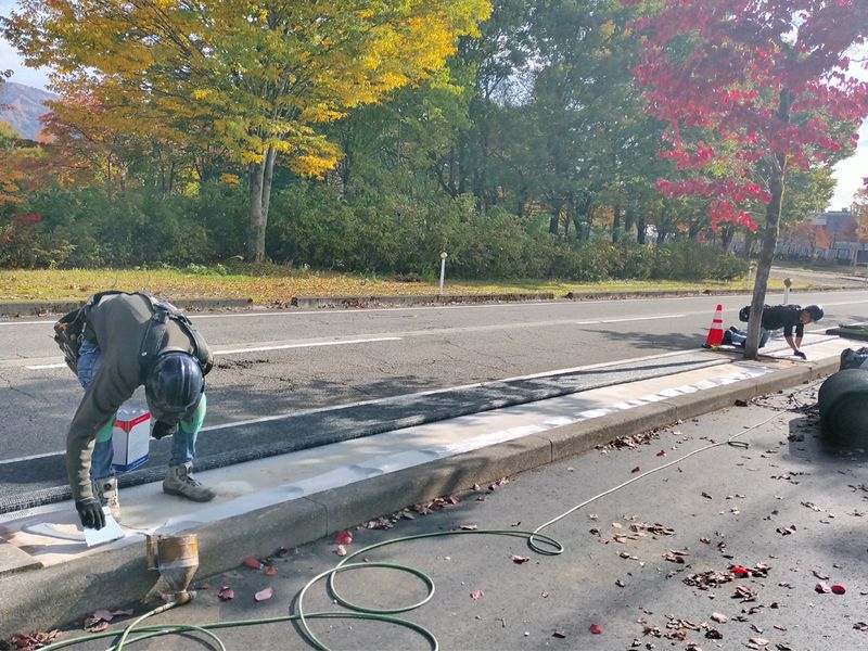 こてを使い、コンクリートに接着剤を塗り付ける